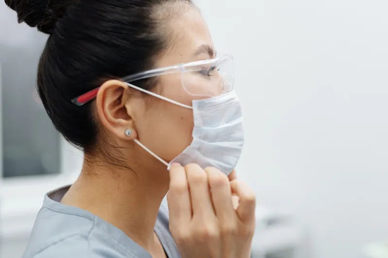 Kvinna vill hindra infektion har en ansiktsmask. Få behandling mot infektioner online. ReceptOnline.se